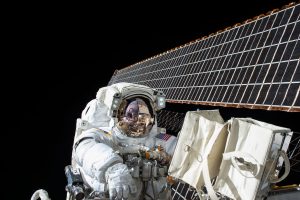 An astronaut in a spacewalk with a solar panel behind him