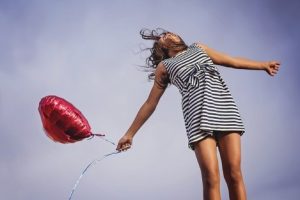 Smiling girl with a helium baloon.