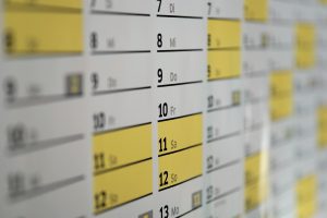 A wall calendar with yellow and white dates.