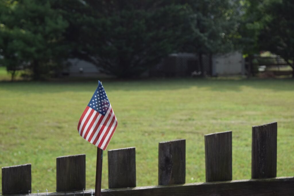A wooden fence with American flag
