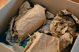 Box with objects wrapped in brown paper 