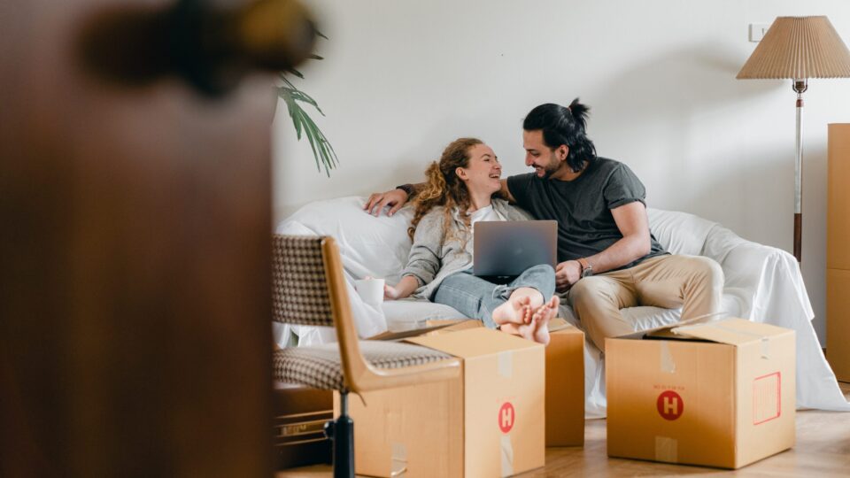 couple smiling amid moving boxes