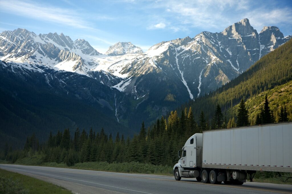 A moving truck on a highway with mountains in the background