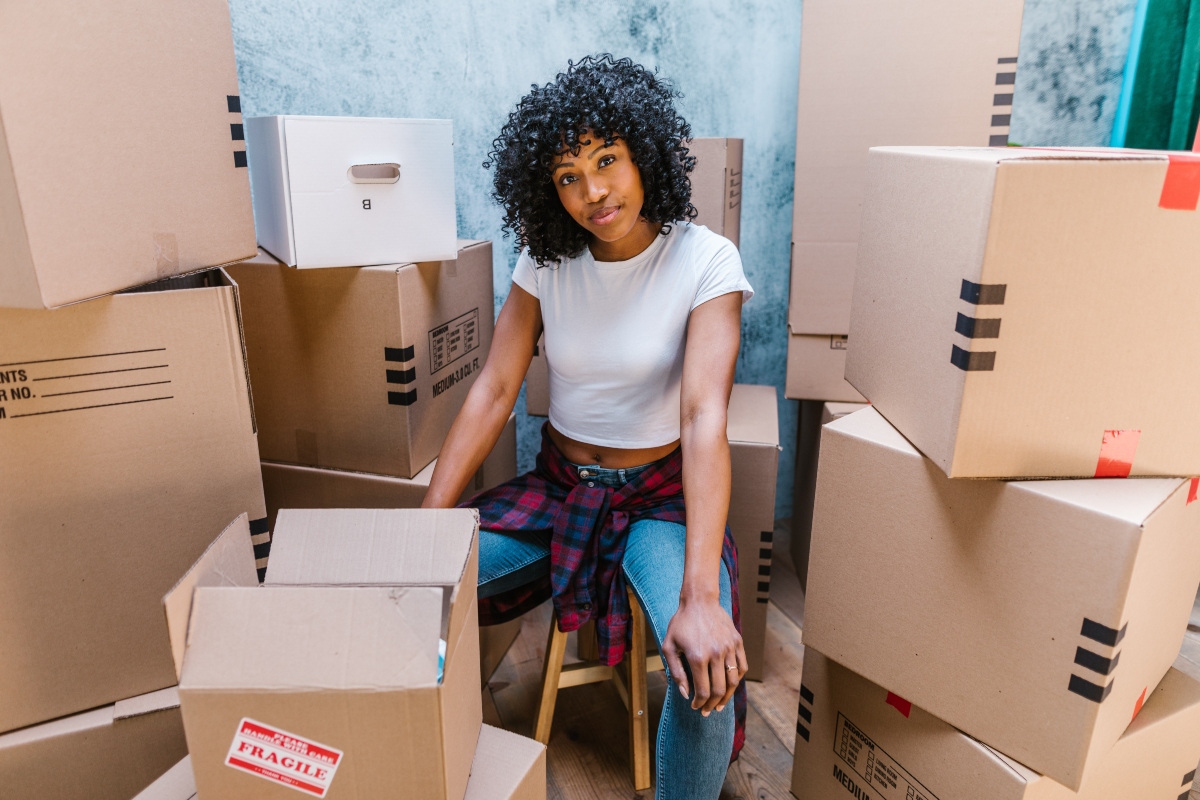 beautiful black woman sitting between moving boxes