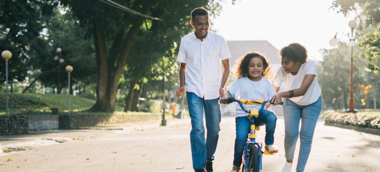 Parents teach a child to ride a bike after moving to some of the best C