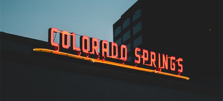 A red sign on a building that says "Colorado Springs" 