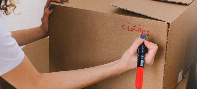 a person writing 'clothes' on the box