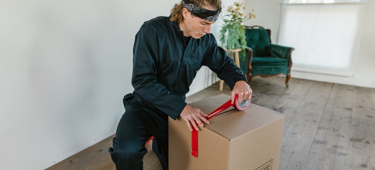 A mover sealing a moving box as a representative of top movers in Tulsa