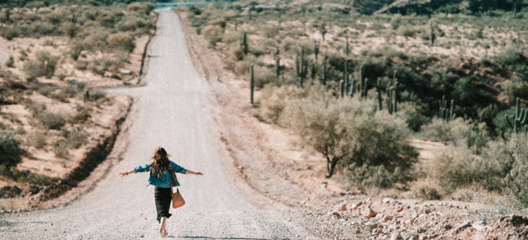 A woman walking on a dirt road in Arizona.